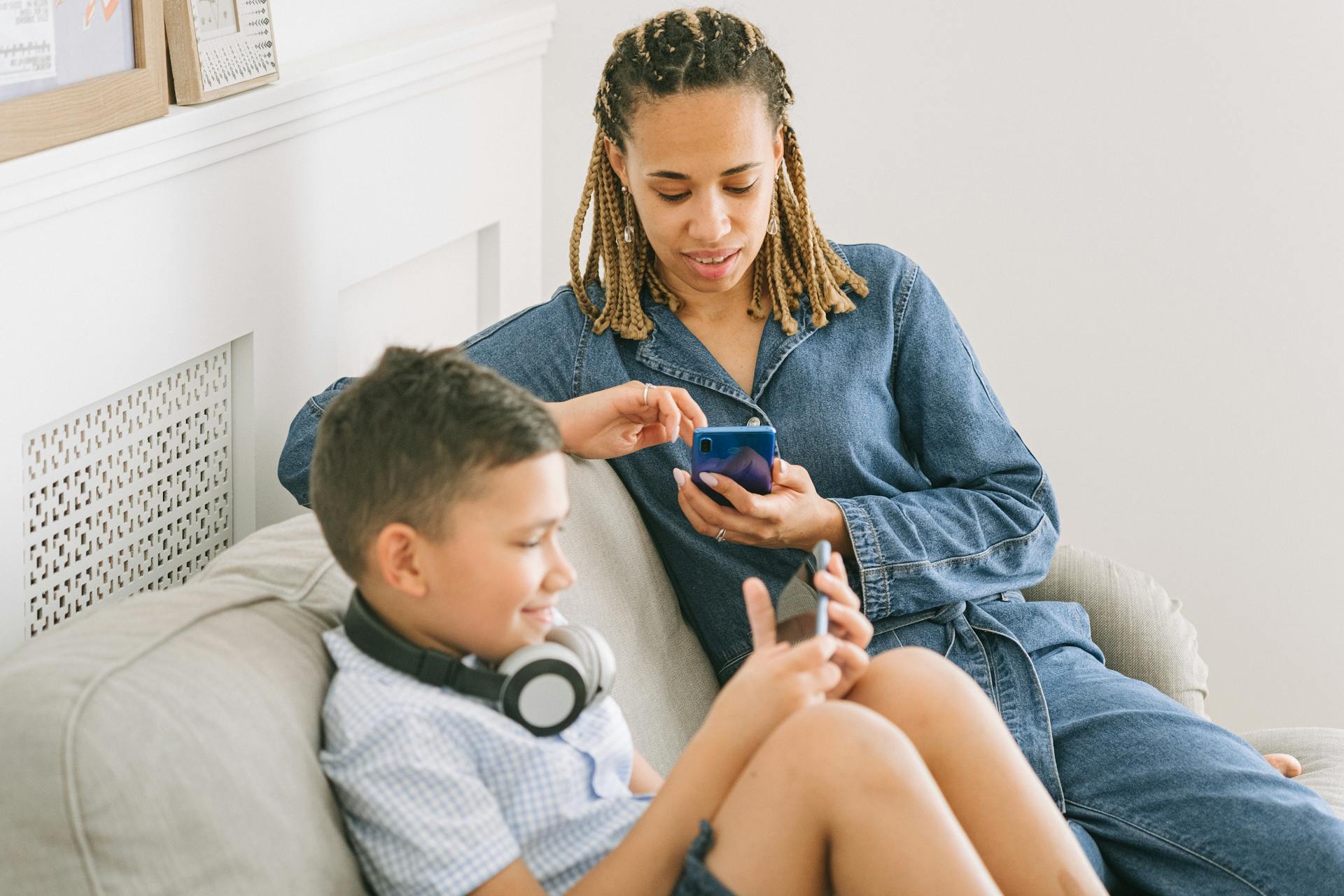 A parent helping a child use a smartphone
